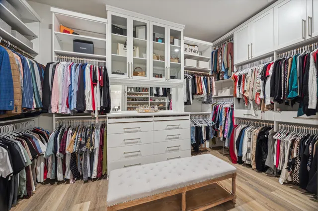a view of walk in closet with clothes and shoes