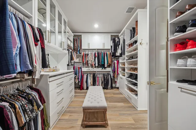 a view of walk in closet with clothes and shoes
