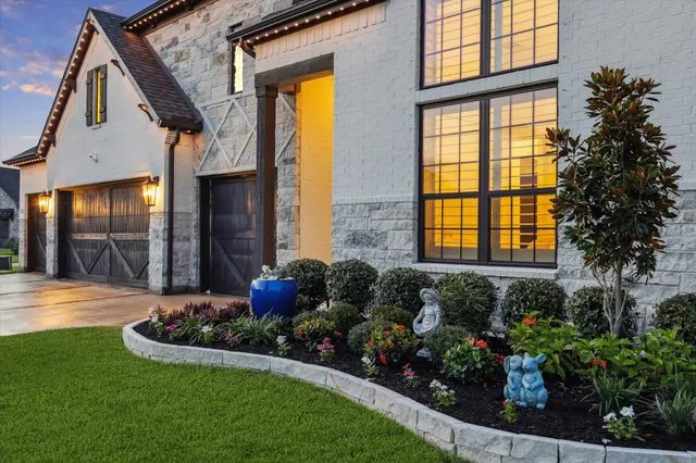 a view of a house with brick walls and flower plants