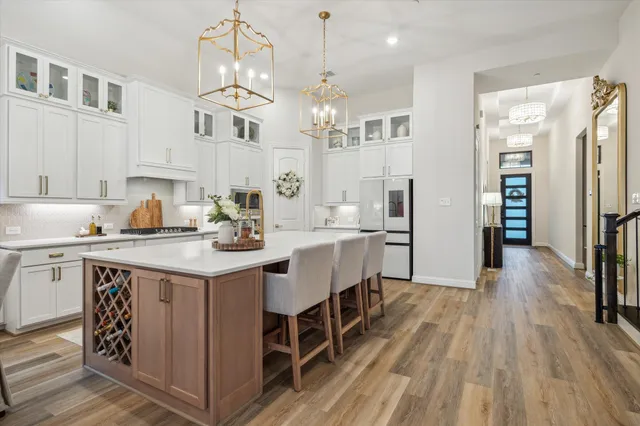 a kitchen with a sink dishwasher a dining table and chairs with wooden floor