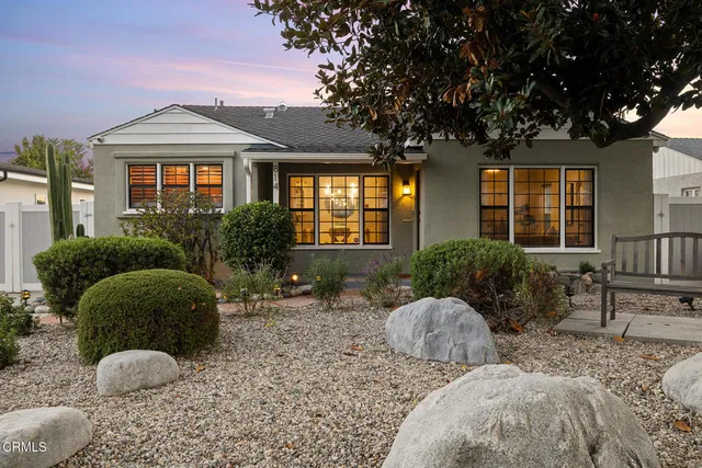 a front view of house with a garden