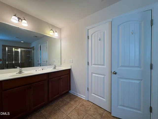 a bathroom with a double vanity sink and mirror