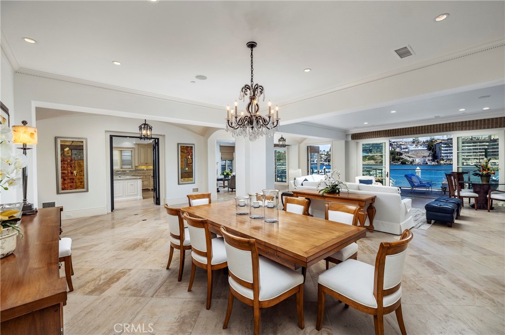 2258 Channel Road Newport Beach, CA 92661 - Photo 11 of 54 a dining room with wooden floor a chandelier a wooden table and chairs