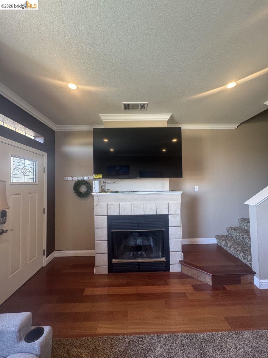 3623 Wells Road Oakley, CA 94561 - Photo 9 of 59 Fireplace with tile surround and mantel, wood-finish flooring, recessed lighting, and crown molding