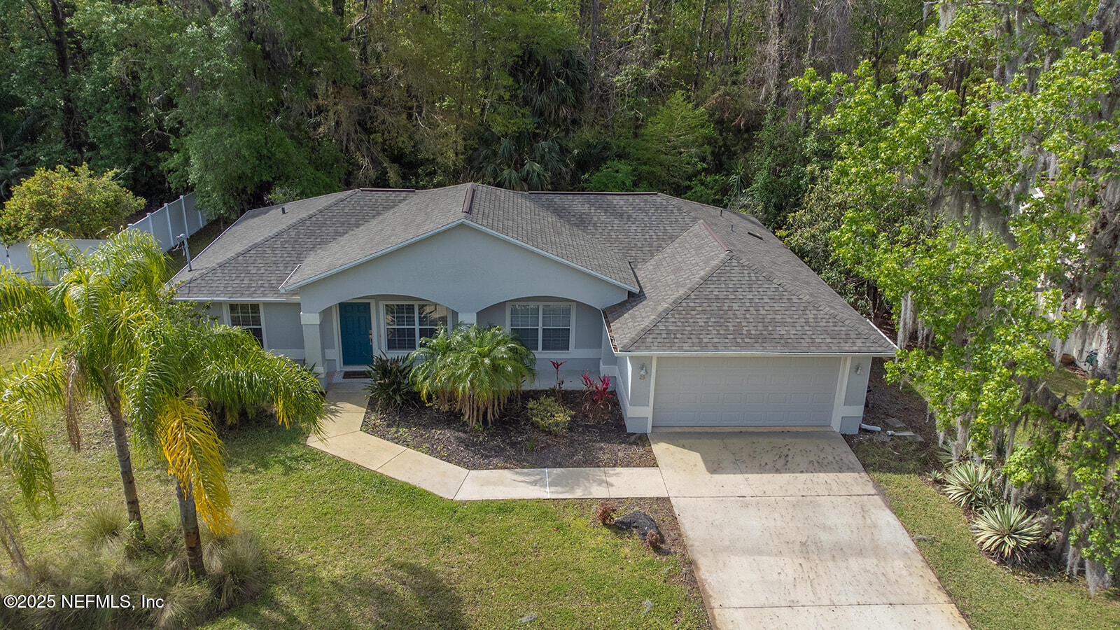 a front view of a house with a yard and potted plants
