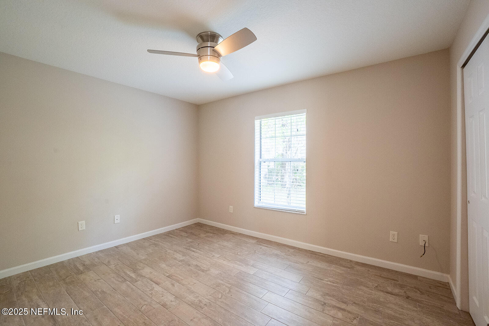 29 Edith Pope Drive Palm Coast, FL 32164 - Photo 19 of 26 an empty room with wooden floor and windows