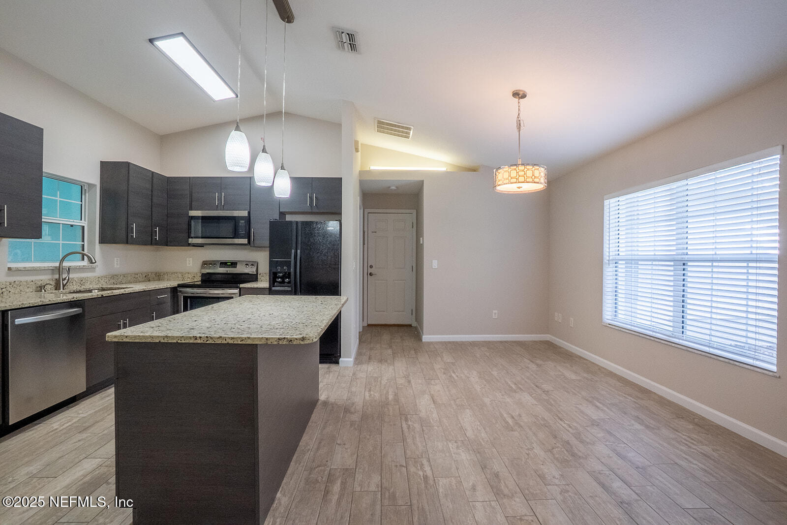 29 Edith Pope Drive Palm Coast, FL 32164 - Photo 9 of 26 a kitchen with kitchen island granite countertop a sink cabinets and a wooden floor