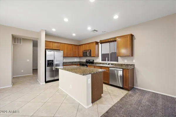 a kitchen with stainless steel appliances granite countertop a refrigerator and a stove top oven