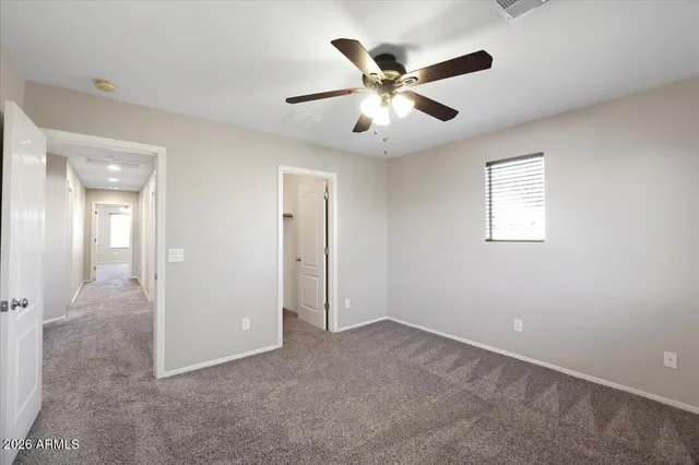 an empty room with a window and ceiling fan