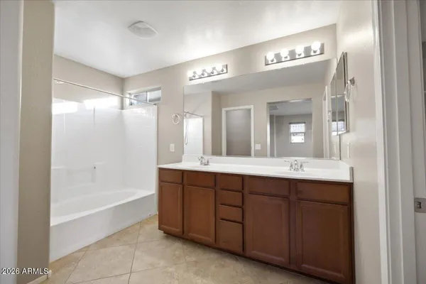 a spacious bathroom with a bathtub sink and mirror