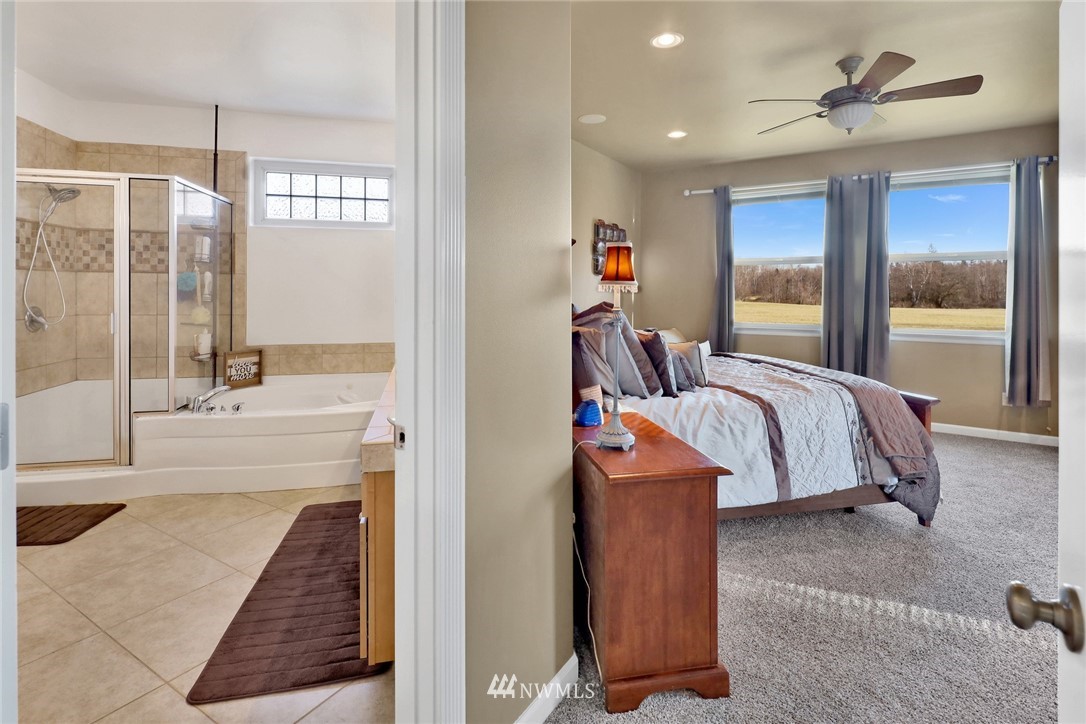 1107 Slater Road Bellingham, WA 98226 - Photo 30 of 39 a spacious bedroom with a large bed and a chandelier