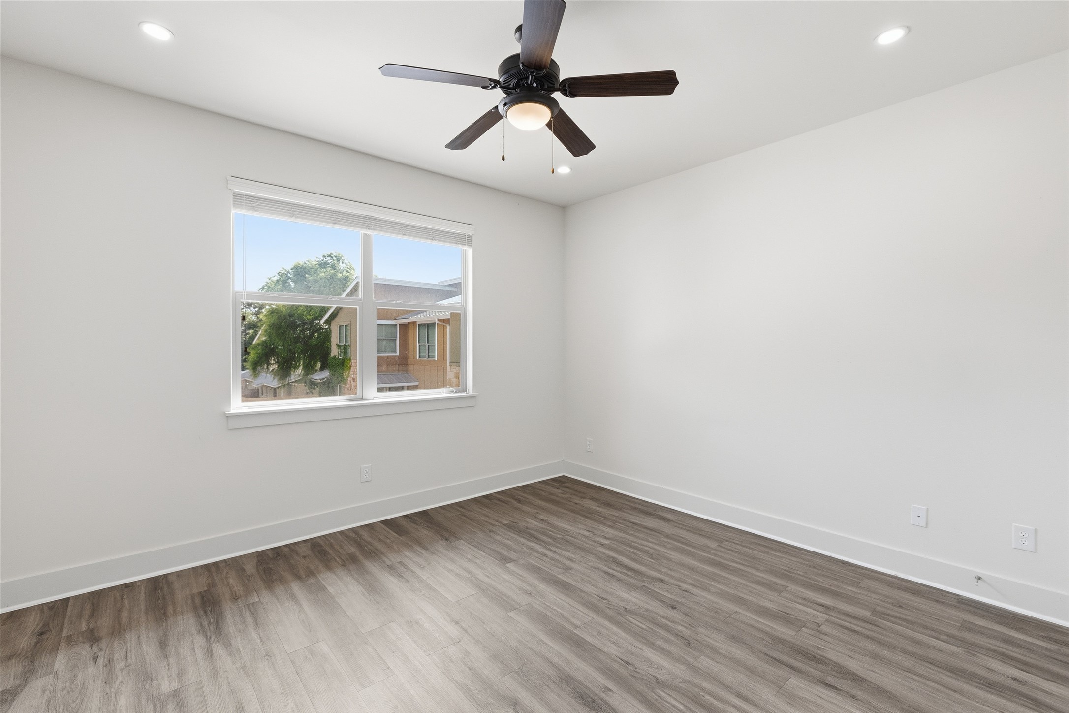 4124 Valley View Road, Unit 4B Austin, TX 78704 - Photo 28 of 32 A quiet bedroom with a ceiling fan, window for natural light, and modern wood-look flooring.