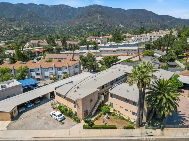 an aerial view of residential houses with outdoor space and parking
