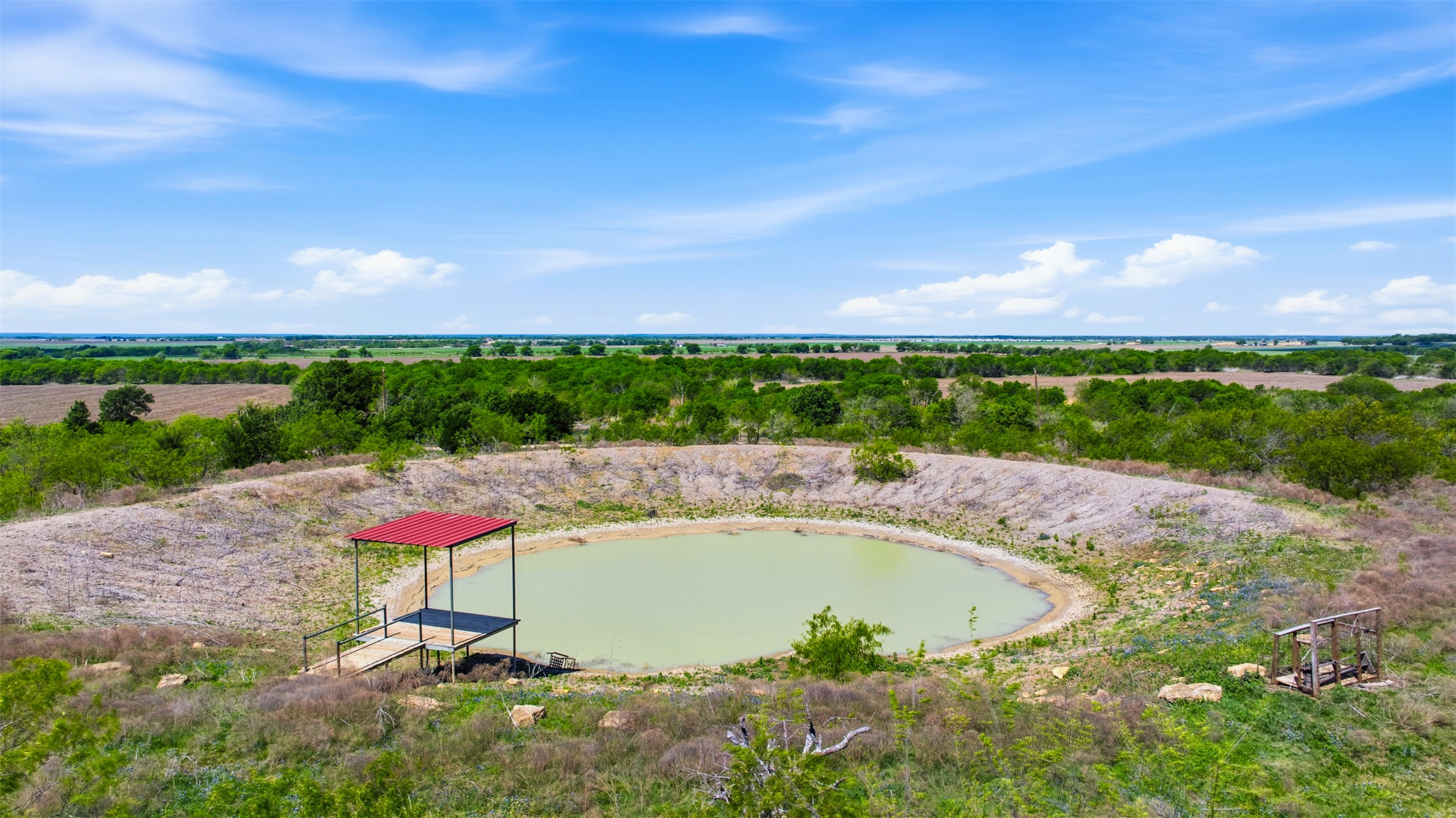 6947 Moody Road Moody, TX 76557 - Photo 16 of 24 An aerial perspective showcases a circular pond with a covered dock on expansive acreage.