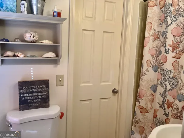 a bathroom with a toilet and a shower curtain