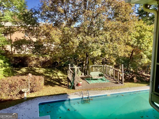 a view of yard with swimming pool and trees