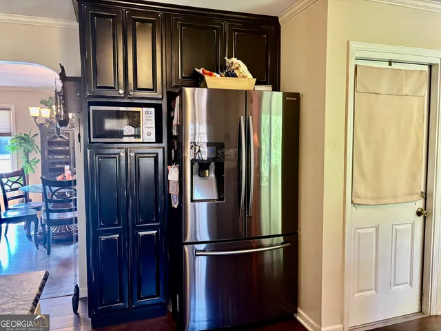 a kitchen with stainless steel appliances granite countertop a refrigerator and a wooden floor