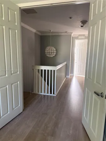 a view of a hallway and wooden floor