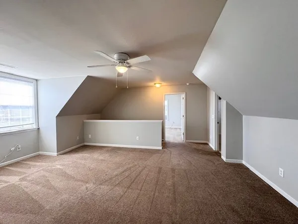 a view of a livingroom with a ceiling fan and window