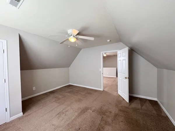 an empty room with closet and a chandelier fan