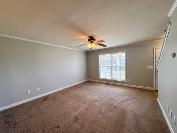 a view of a livingroom with a ceiling fan and window