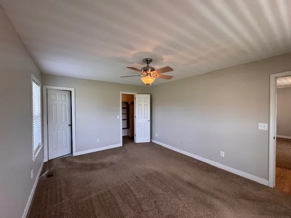 a view of a livingroom with a ceiling fan and window