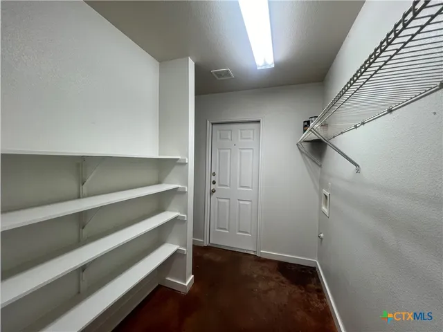 a view of walk in closet with empty racks