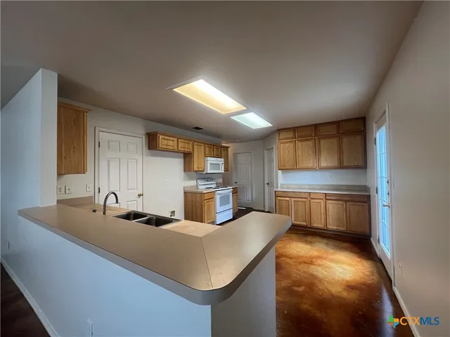 a kitchen with kitchen island granite countertop a sink cabinets and counter space