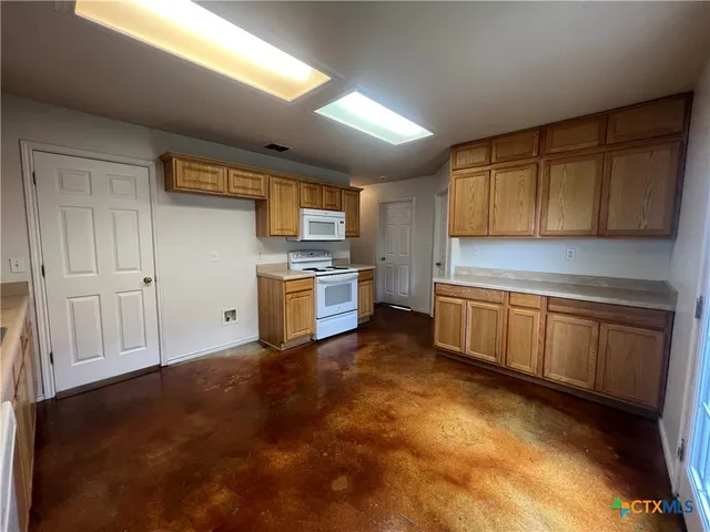 a kitchen with a refrigerator sink and cabinets