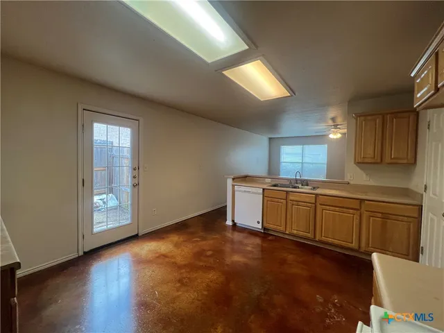 a large kitchen with cabinets and wooden floor