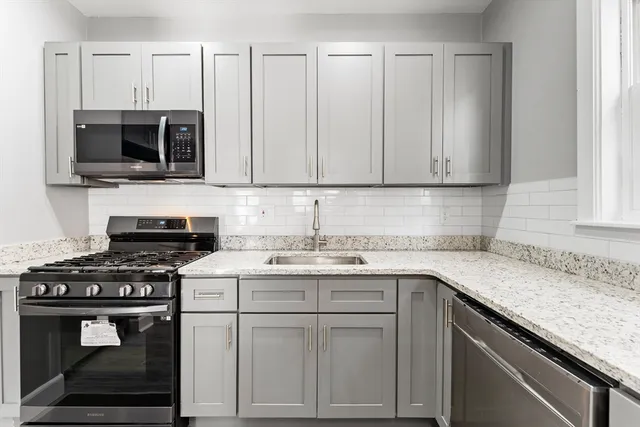 a kitchen with appliances a sink and cabinets