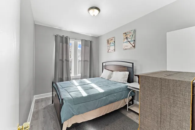 a bedroom with a bed and painting on the wall