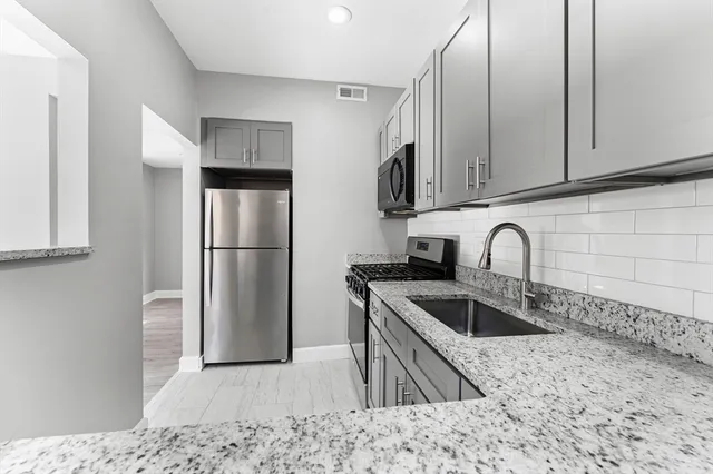 a kitchen with stainless steel appliances granite countertop a sink stove and refrigerator