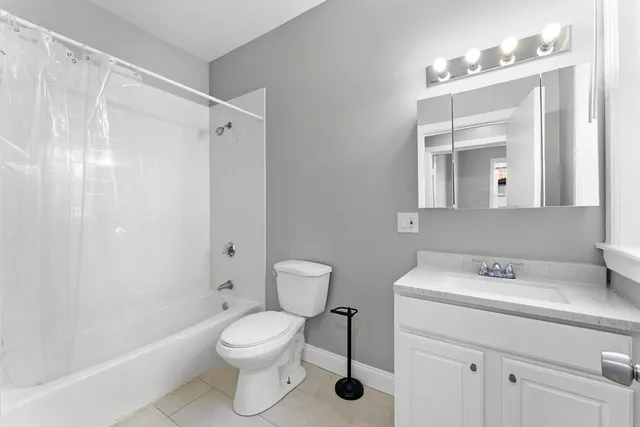 a bathroom with a toilet sink vanity and shower