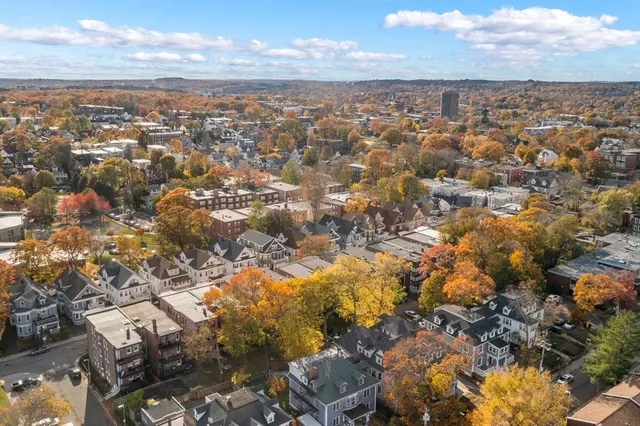 a row of parked cars in front of brick building