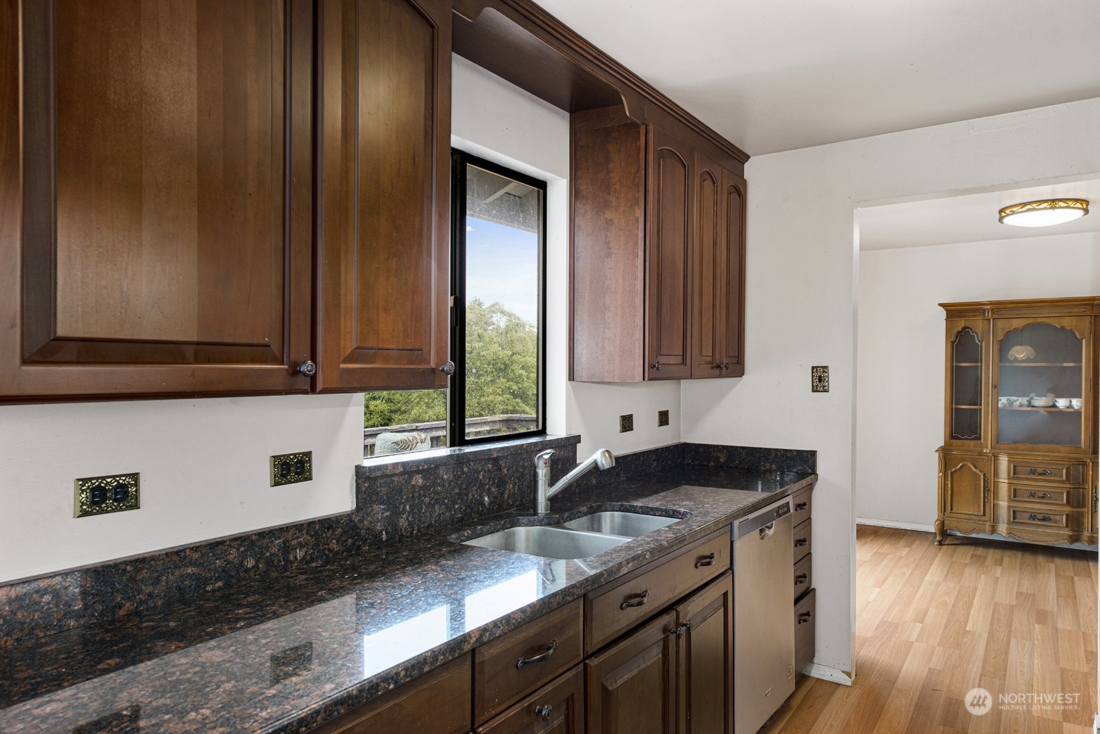 5606 Southwest 244th Street Vashon, WA 98070 - Photo 12 of 40 a kitchen with granite countertop wooden cabinets a sink and dishwasher next to a window