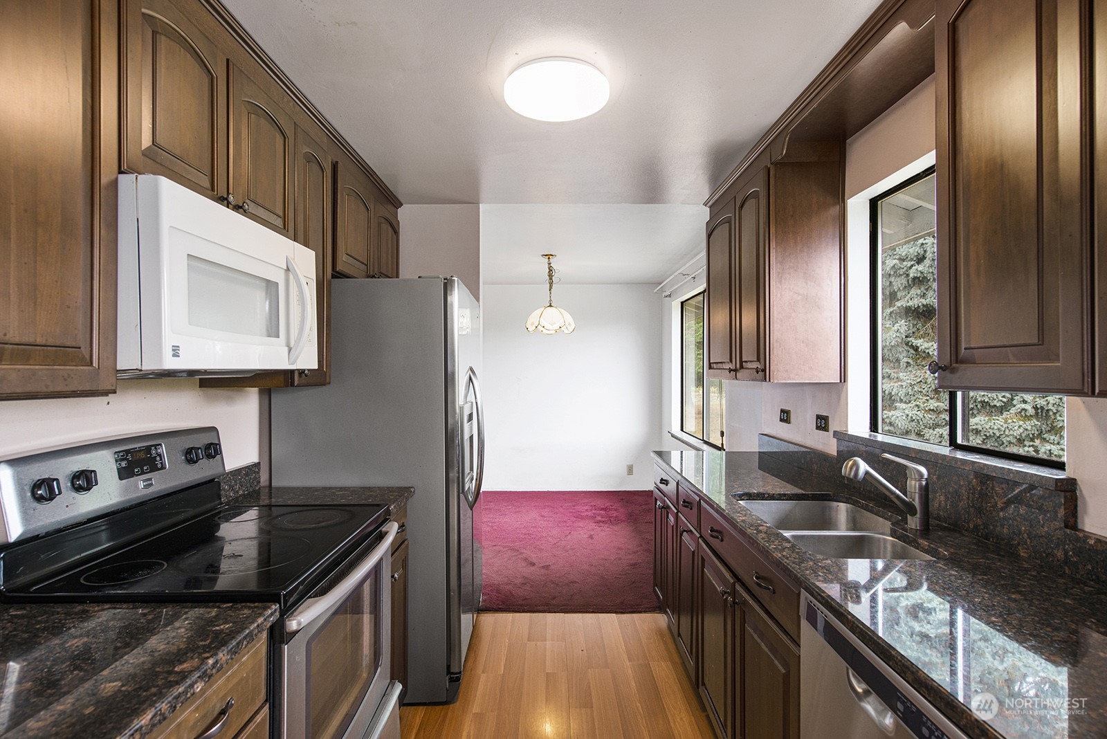 5606 Southwest 244th Street Vashon, WA 98070 - Photo 14 of 40 a kitchen with granite countertop stainless steel appliances a stove sink and cabinets