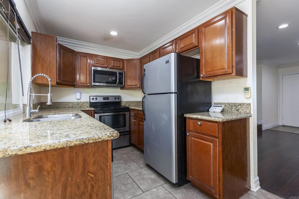 309 Sun Court El Cajon, CA 92021 - Photo 15 of 39 a kitchen with stainless steel appliances granite countertop a refrigerator a stove top oven a sink and dishwasher