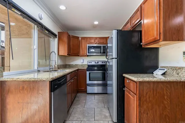 a kitchen with granite countertop stainless steel appliances and wooden cabinets