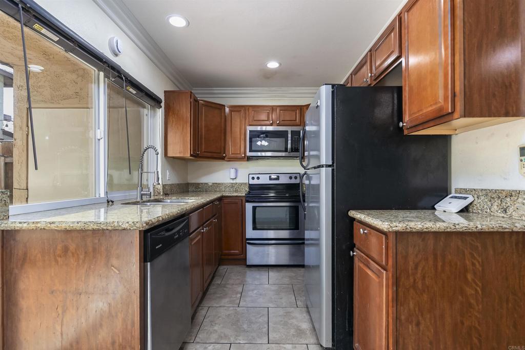 309 Sun Court El Cajon, CA 92021 - Photo 17 of 39 a kitchen with granite countertop stainless steel appliances and wooden cabinets