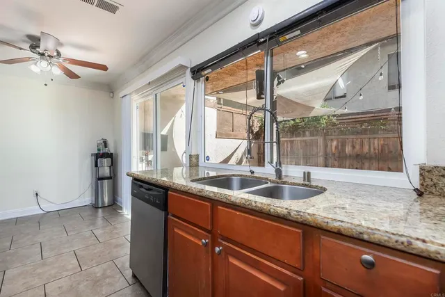 a kitchen with granite countertop a sink and a refrigerator