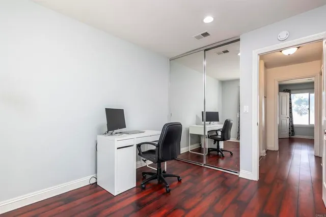 a view of a workspace with wooden floor and a bathroom