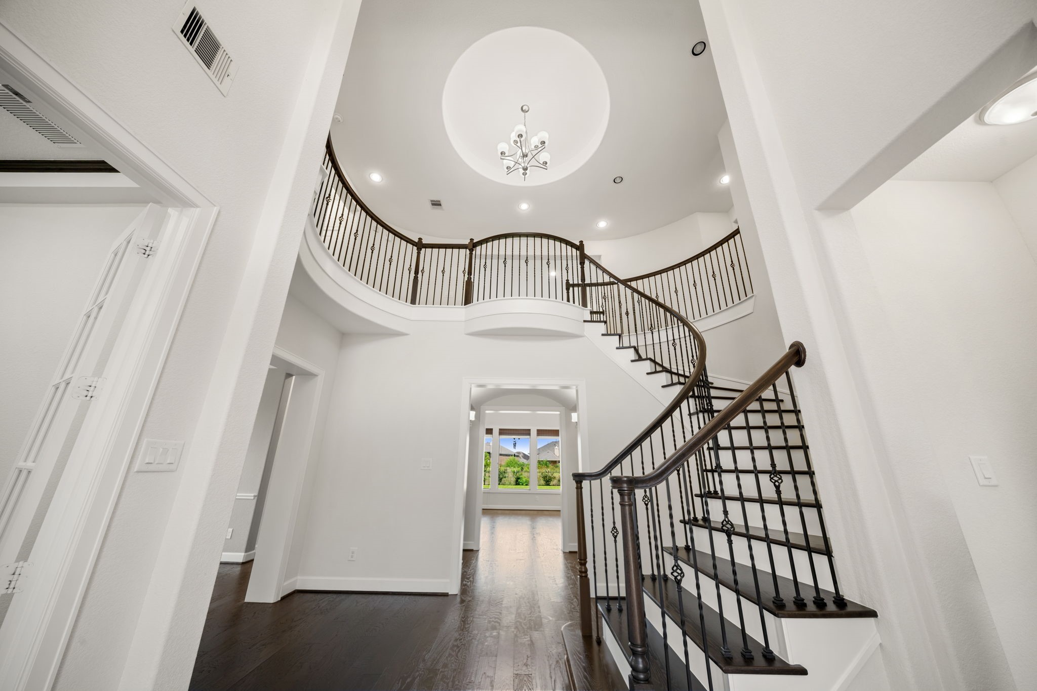 3622 Sage Hollow Drive Spring, TX 77386 - Photo 4 of 46 Step inside the double-volume foyer highlighted by a sweeping curved staircase with stained wood treads and elegant wrought iron balustrades custom-matched to the home's hardwood flooring.