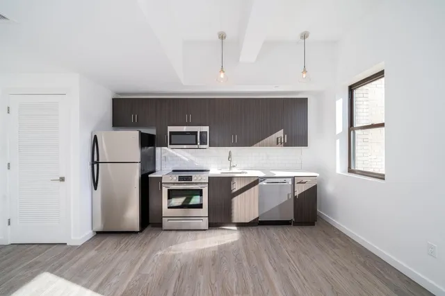 a kitchen with a refrigerator and a stove top oven