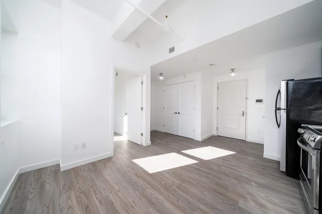 a view of a kitchen with wooden floor and a refrigerator