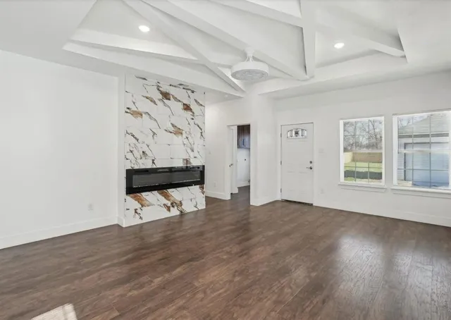 an empty room with wooden floor and wall painting