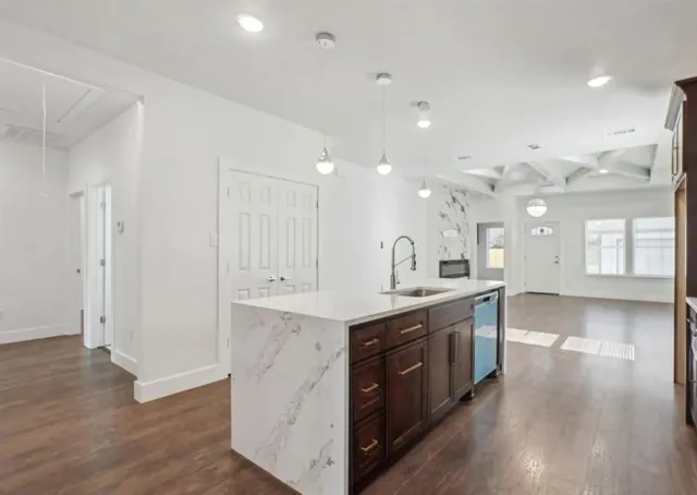 a large kitchen with stainless steel appliances granite countertop a large counter top and a wooden floors