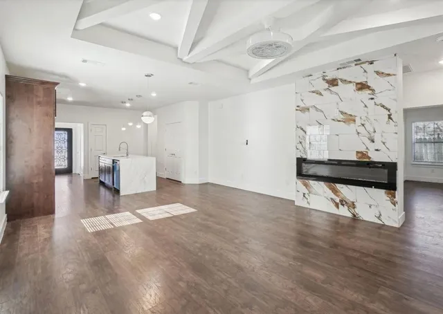 a view of a hallway with wooden floor and seating space