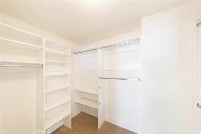 a bathroom with a granite countertop double vanity sink a mirror and a shower