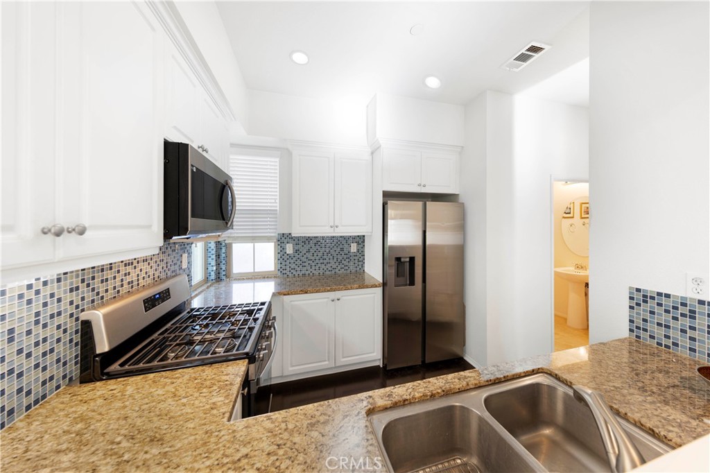 90 Hedge Bloom Irvine, CA 92618 - Photo 8 of 22 a kitchen with stainless steel appliances granite countertop a sink and a refrigerator